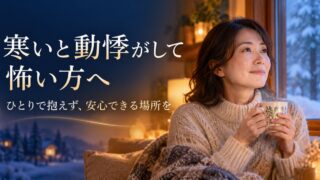 寒いと動悸がして怖い方へ。ひとりで抱えず、安心できる場所を。窓辺でカップを持つ女性のイメージ
